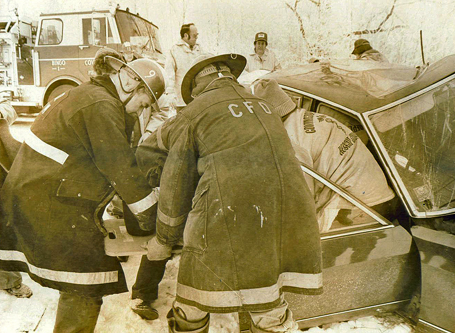 old photo of firefighters rescuing someone from a car