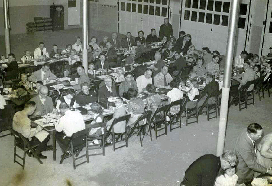 black and white photo of people sitting at tables at a party