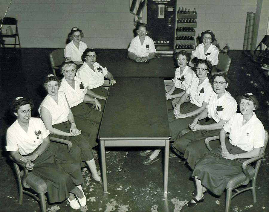 black and white photo of women sitting around a table and smiling