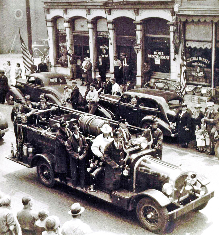 black and white photo of firetrucks in a parade