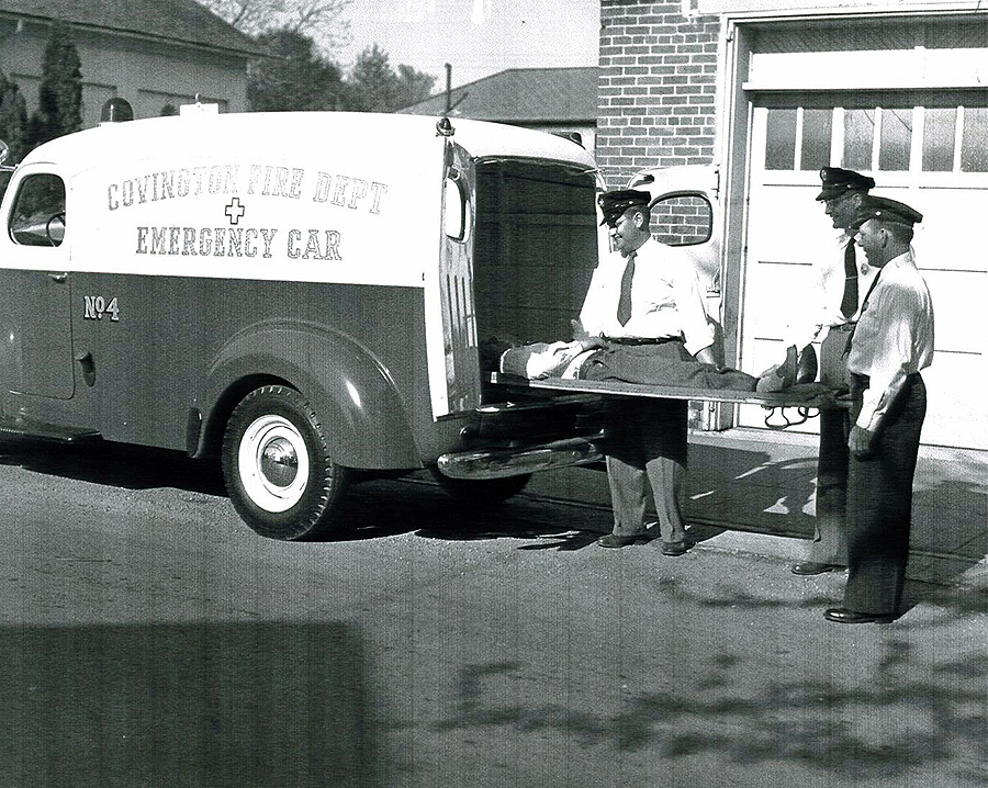 black and white photo of a person being loaded into the fire department emergency car
