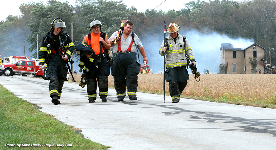 firefighters walking away after fighting a house fire
